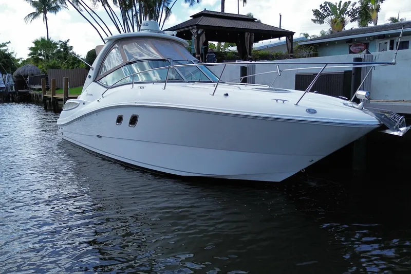 Slide: The Image of 2007 Sea Ray Sundancer 310 yacht docked on calm water, surrounded by tropical scenery. - 16