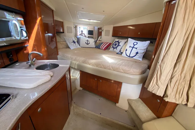 Slide: The Image of Interior of 2007 Sea Ray Sundancer 310 with nautical-themed decor and compact kitchenette. - 35