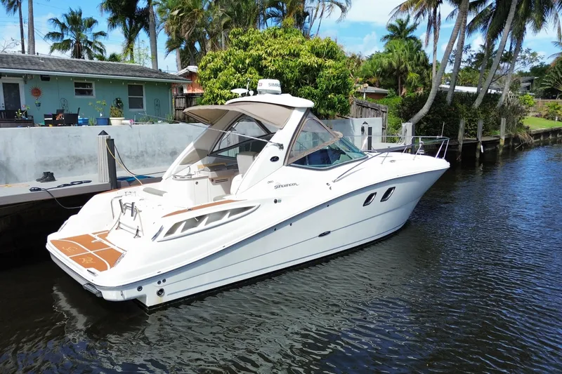 Slide: The Image of 2007 Sea Ray Sundancer 310 yacht docked by palm trees in a serene canal setting. - 43