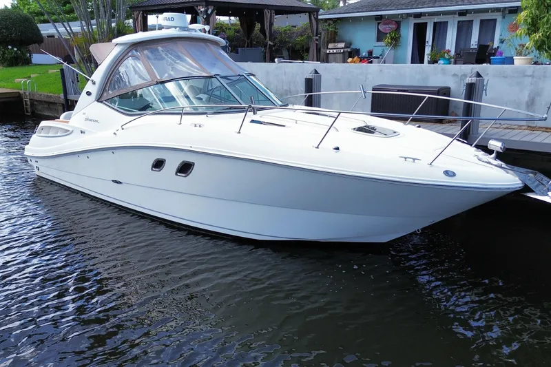 Slide: The Image of 2007 Sea Ray Sundancer 310 boat docked in a serene waterfront setting. - 6