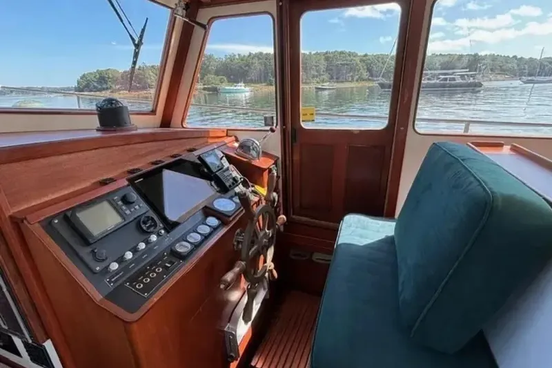 Slide: The Image of Interior of 2003 Snug Harbor Shearwater boat with navigation controls and scenic water view. - 11