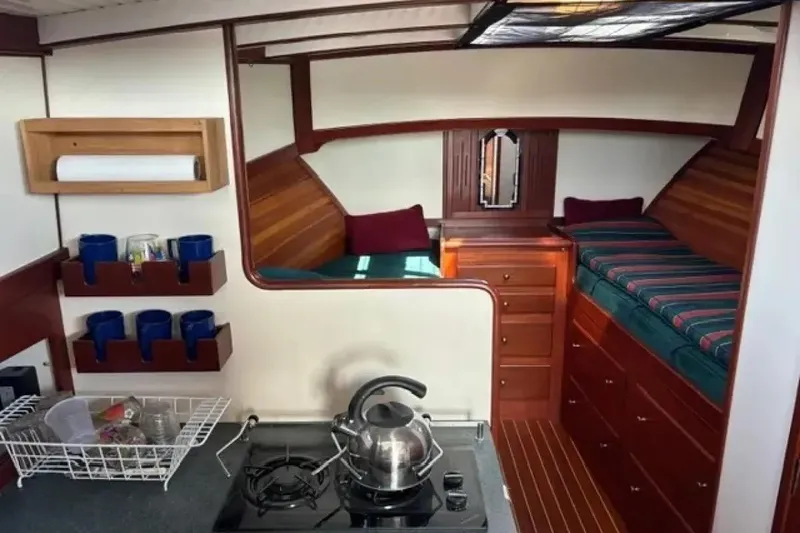 Slide: The Image of Cozy 2003 Snug Harbor Shearwater boat interior with kitchenette and sleeping area. - 15