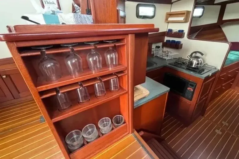 Slide: The Image of Interior of 2003 Snug Harbor Shearwater yacht with kitchen and glassware storage. - 17