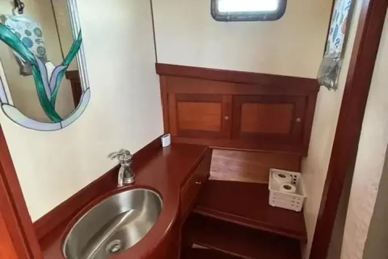 Slide: The Image of 2003 Snug Harbor Shearwater boat bathroom with wooden cabinetry and stainless steel sink. - 23