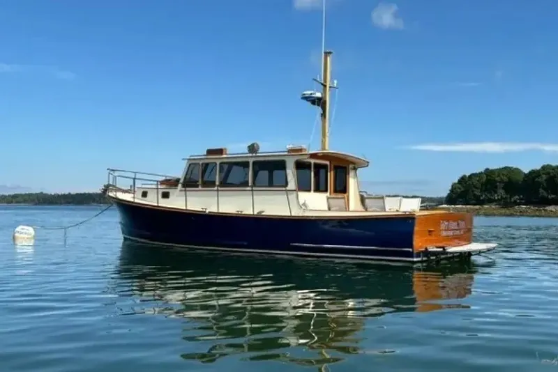 Slide: The Image of 2003 Snug Harbor Shearwater boat anchored on calm water under clear blue sky. - 38