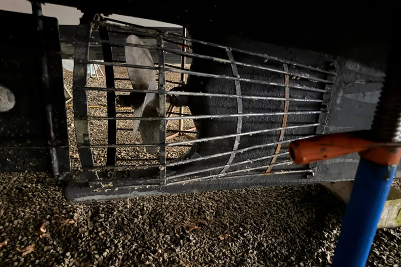 Slide: The Image of Propeller of 2003 Snug Harbor Shearwater boat with protective cage on gravel surface. - 8