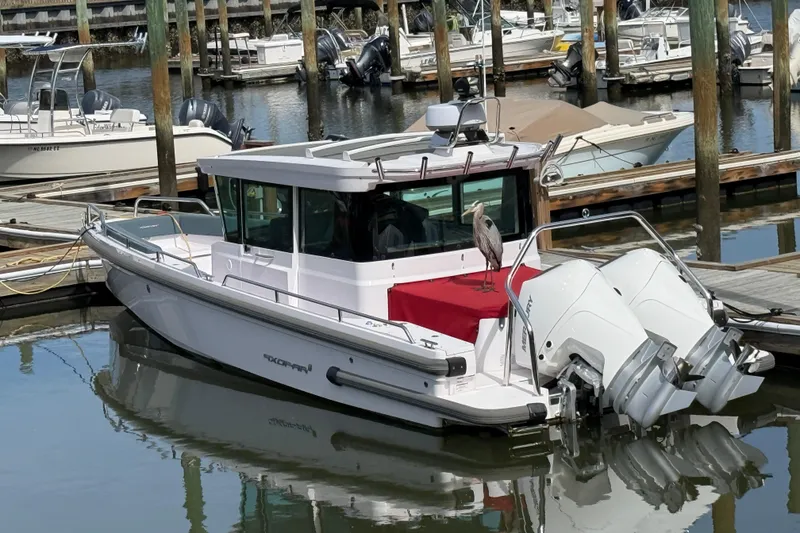 The Image of 2022 Axopar 28 Cabin boat docked with a bird perched on the deck. - 1