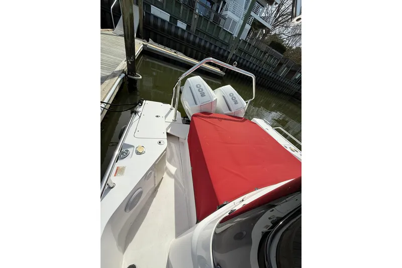 Slide: The Image of 2022 Axopar 28 Cabin boat with red cover, docked by the water. - 4