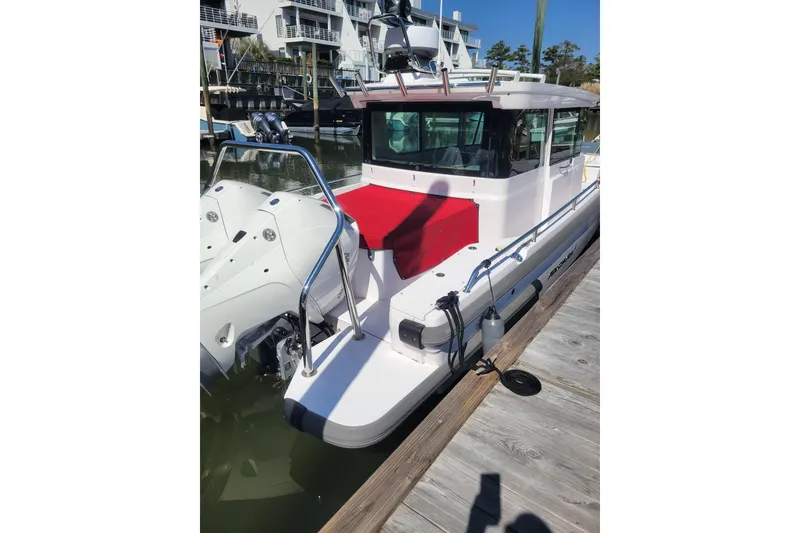 Slide: The Image of 2022 Axopar 28 Cabin boat docked, featuring sleek design and modern amenities. - 5