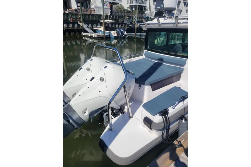 Slide: The Image of 2022 Axopar 28 Cabin boat with dual outboard motors docked in marina. - 7