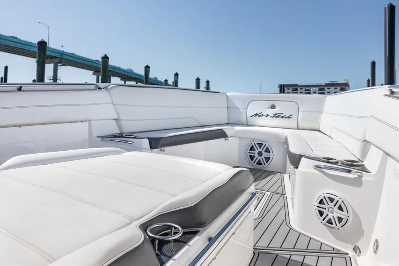 Slide: The Image of 2018 Nor-Tech 390 Sport Center Console boat interior with white seating and speakers. - 10