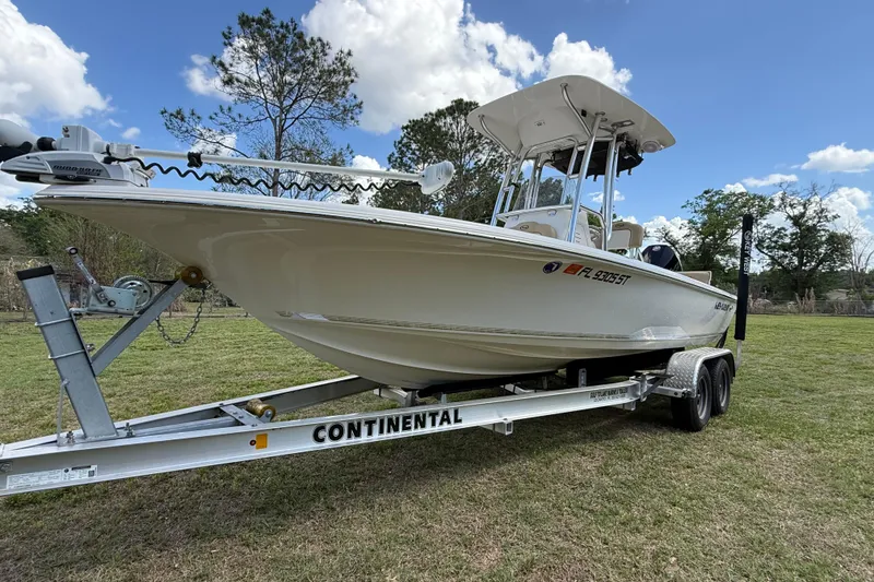 Slide: The Image of 2020 Key West 230 Bay Reef boat on trailer, parked on grass under blue sky. - 1