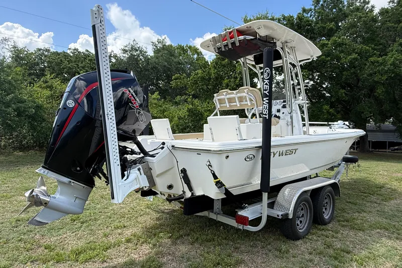 Slide: The Image of 2020 Key West 230 Bay Reef boat on trailer, featuring powerful outboard motor. - 12