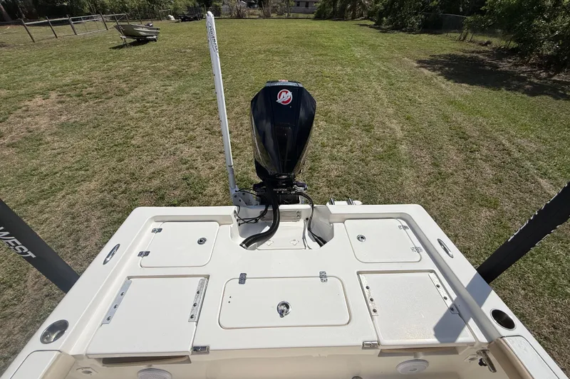 Slide: The Image of 2020 Key West 230 Bay Reef boat with outboard motor on grassy area. - 14