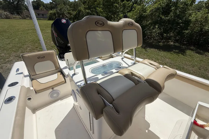 Slide: The Image of 2020 Key West 230 Bay Reef boat interior with cushioned seating and motor. - 17
