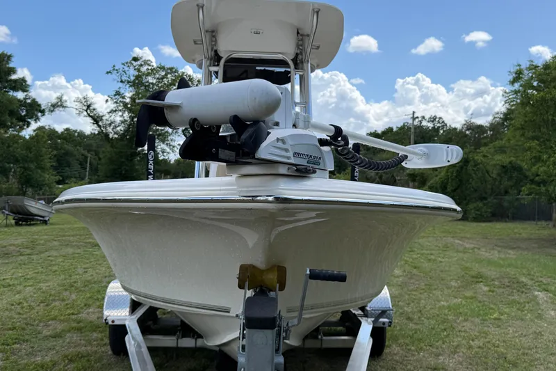 Slide: The Image of 2020 Key West 230 Bay Reef boat on trailer, grassy area, clear sky background. - 2