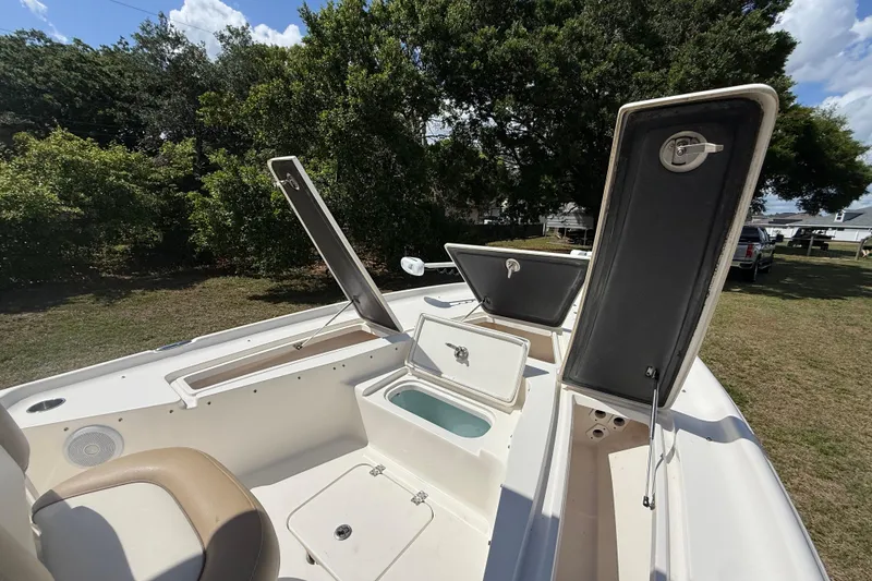 Slide: The Image of 2020 Key West 230 Bay Reef boat with open storage compartments, set outdoors. - 23