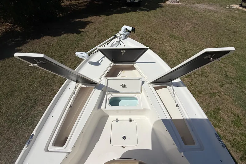 Slide: The Image of 2020 Key West 230 Bay Reef boat with open storage compartments on grassy area. - 24