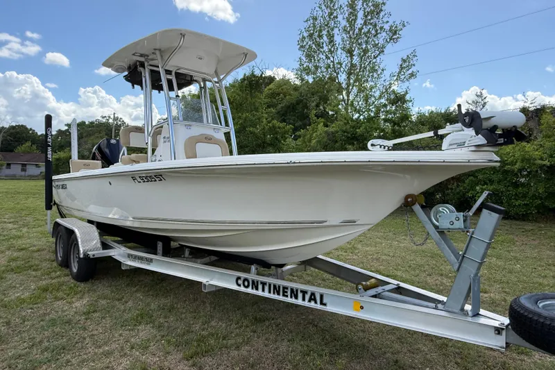 Slide: The Image of 2020 Key West 230 Bay Reef boat on trailer, parked on grass under a blue sky. - 3