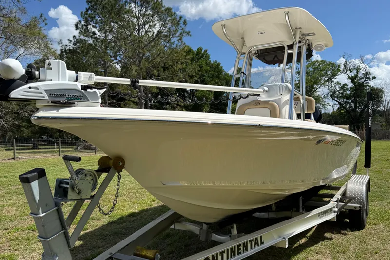 Slide: The Image of 2020 Key West 230 Bay Reef boat on trailer, parked on grass under blue sky. - 6