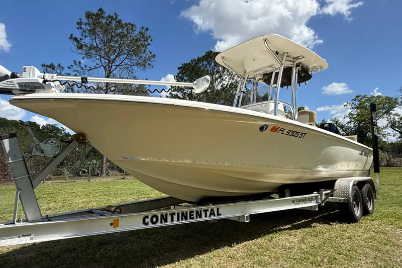 Slide: The Image of 2020 Key West 230 Bay Reef boat on trailer, parked outdoors under blue sky. - 8