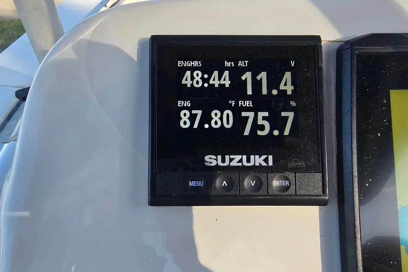 Slide: The Image of Suzuki engine display on 2024 Carolina Skiff 24 Ultra Elite showing hours, voltage, temperature, and fuel. - 16
