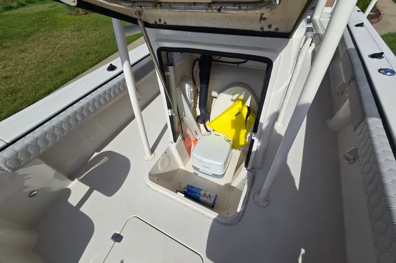 Slide: The Image of 2024 Carolina Skiff 24 Ultra Elite boat storage compartment with safety equipment. - 26