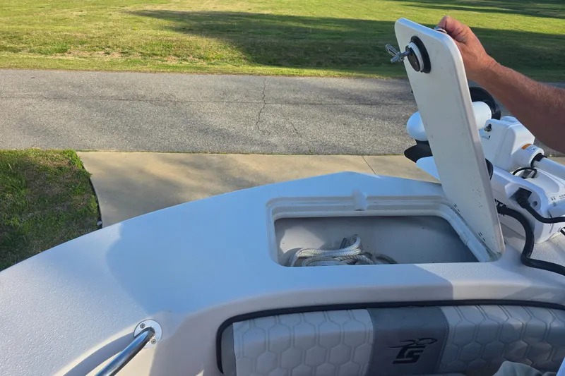 Slide: The Image of 2024 Carolina Skiff 24 Ultra Elite boat with open storage compartment and visible ropes. - 32