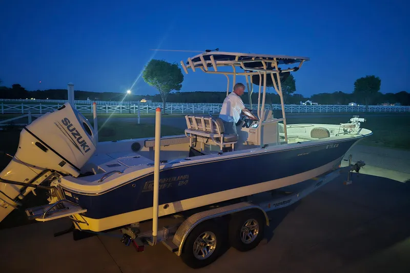 Slide: The Image of 2024 Carolina Skiff 24 Ultra Elite boat on trailer at dusk, with Suzuki engine. - 39