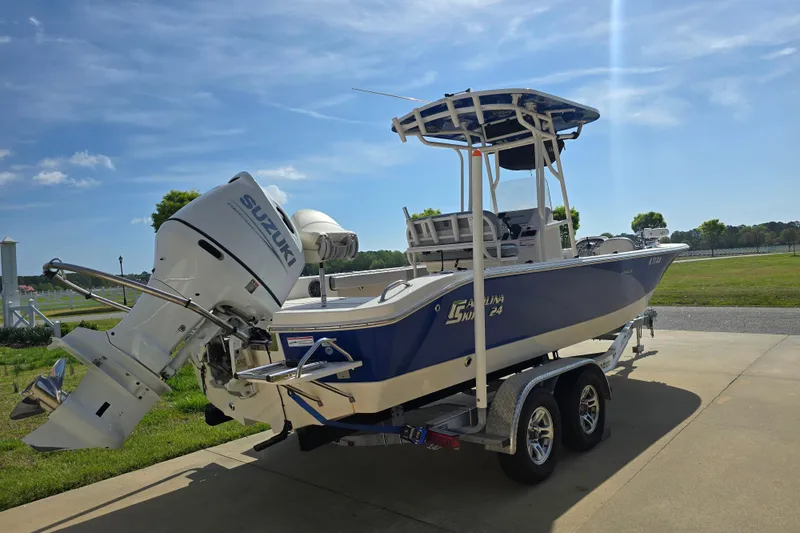 Slide: The Image of 2024 Carolina Skiff 24 Ultra Elite boat on trailer, featuring Suzuki outboard motor. - 4