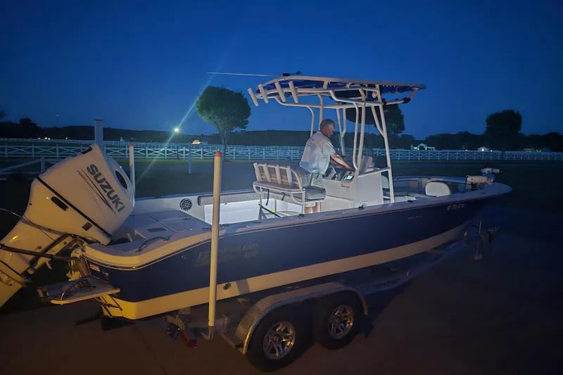 Slide: The Image of 2024 Carolina Skiff 24 Ultra Elite boat with Suzuki engine at night. - 40