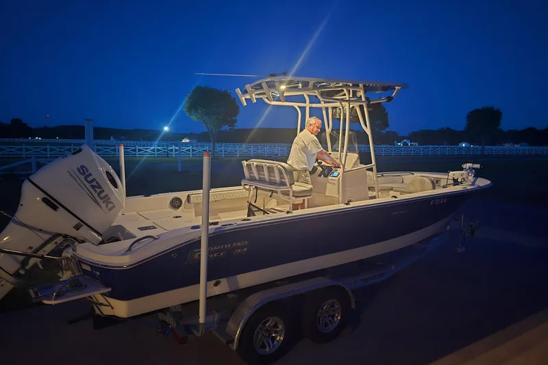 Slide: The Image of 2024 Carolina Skiff 24 Ultra Elite boat illuminated at night with a person onboard. - 41