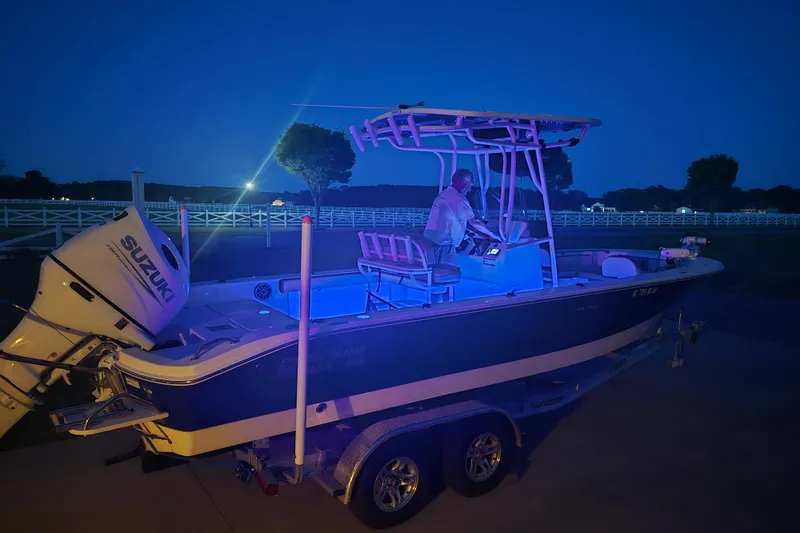 Slide: The Image of 2024 Carolina Skiff 24 Ultra Elite boat illuminated at night with Suzuki engine. - 42