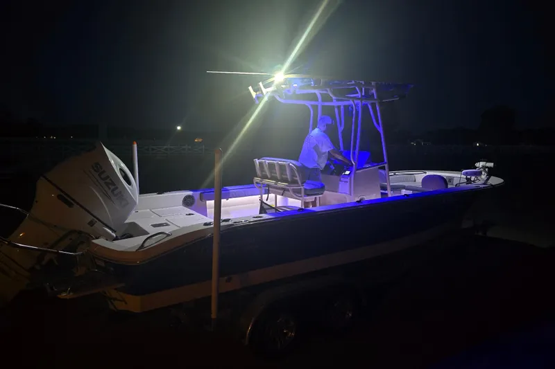 Slide: The Image of 2024 Carolina Skiff 24 Ultra Elite boat illuminated at night with Suzuki engine. - 44