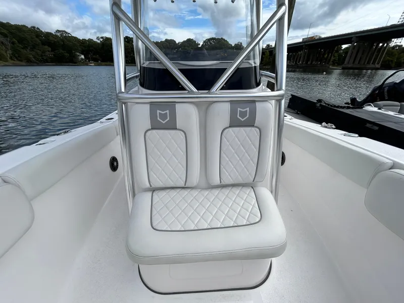 Slide: The Image of 2025 Sea Fox 248 Commander boat interior with cushioned seating on a calm waterway. - 16