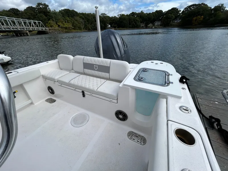 Slide: The Image of 2025 Sea Fox 248 Commander boat interior with seating and storage, docked by a scenic lake. - 27
