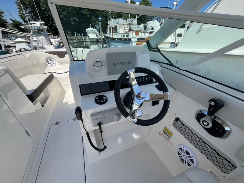 Slide: The Image of 2024 Sailfish 226 DC boat cockpit with Garmin navigation system and steering wheel. - 19