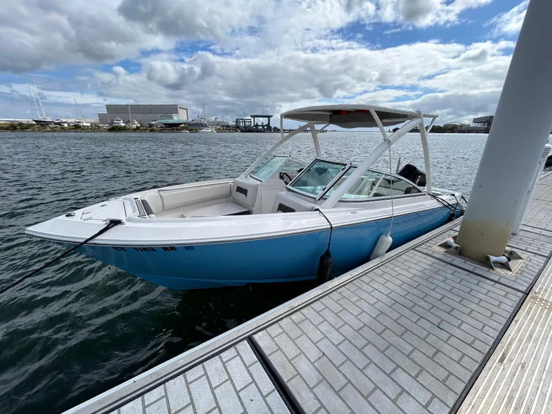 Slide: The Image of 2024 Sailfish 226 DC boat docked on a sunny day. - 2