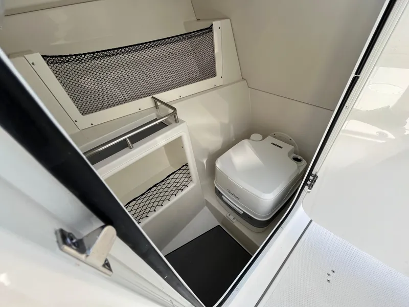 Slide: The Image of 2024 Sailfish 226 DC boat interior with compact toilet and storage. - 22