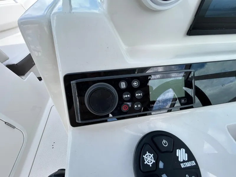 Slide: The Image of 2024 Sailfish 226 DC boat dashboard with Fusion stereo system and controls. - 25