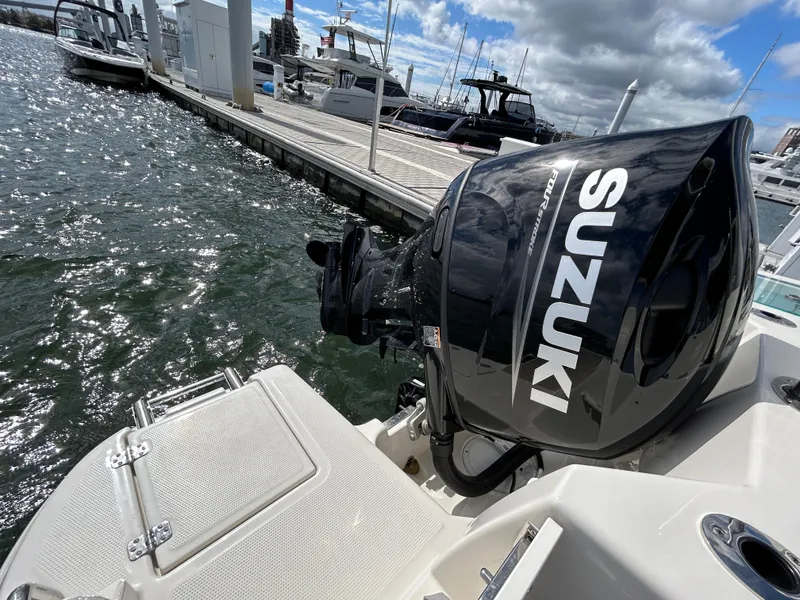 Slide: The Image of 2024 Sailfish 226 DC boat with Suzuki outboard motor docked at marina. - 7