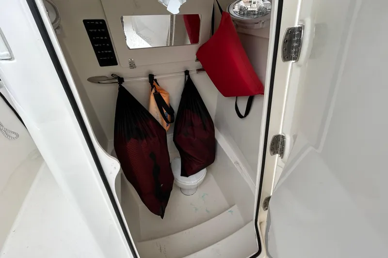 Slide: The Image of 2023 Cobia 240 Center Console interior storage with bags and life jacket. - 10