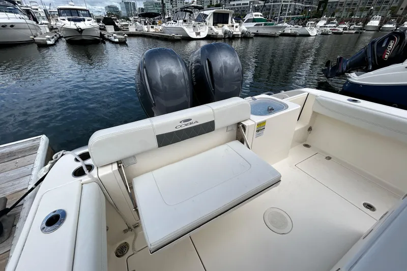 Slide: The Image of 2023 Cobia 240 Center Console boat docked, featuring dual engines and spacious seating area. - 11