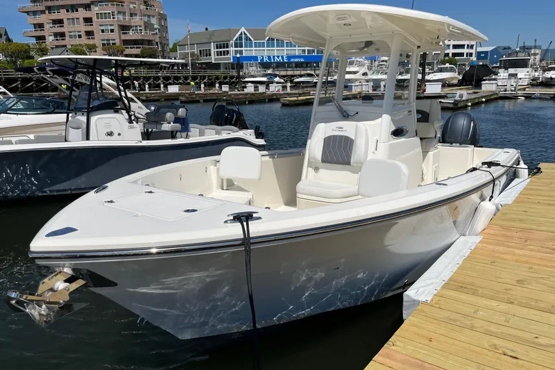 Slide: The Image of 2023 Cobia 240 Center Console boat docked at a marina, showcasing sleek design. - 16