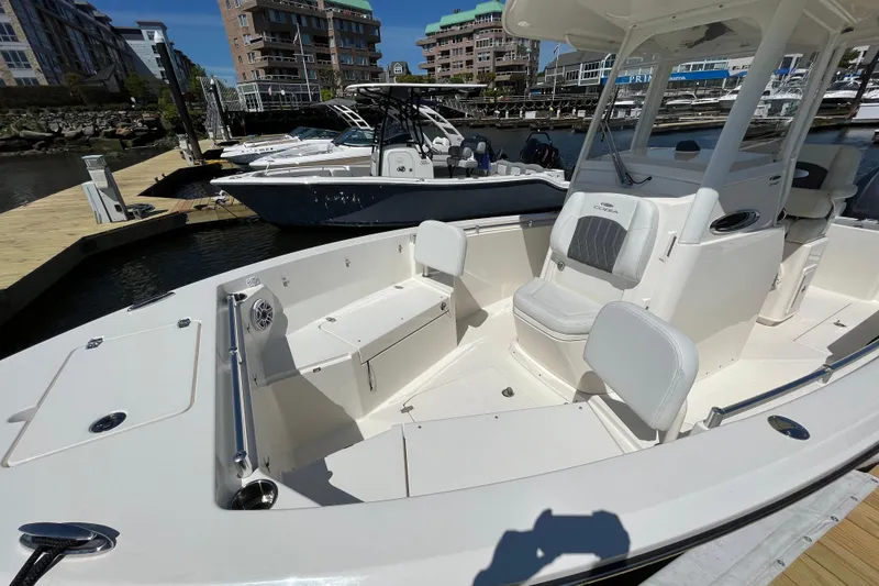 Slide: The Image of 2023 Cobia 240 Center Console boat docked at marina, showcasing spacious seating and modern design. - 17