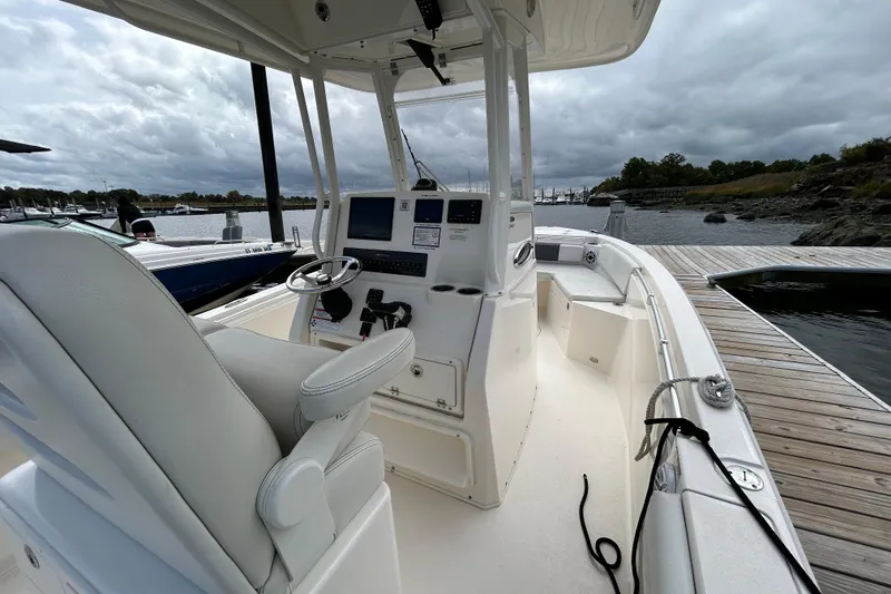 Slide: The Image of 2023 Cobia 240 Center Console boat docked, featuring a sleek helm and spacious seating. - 22