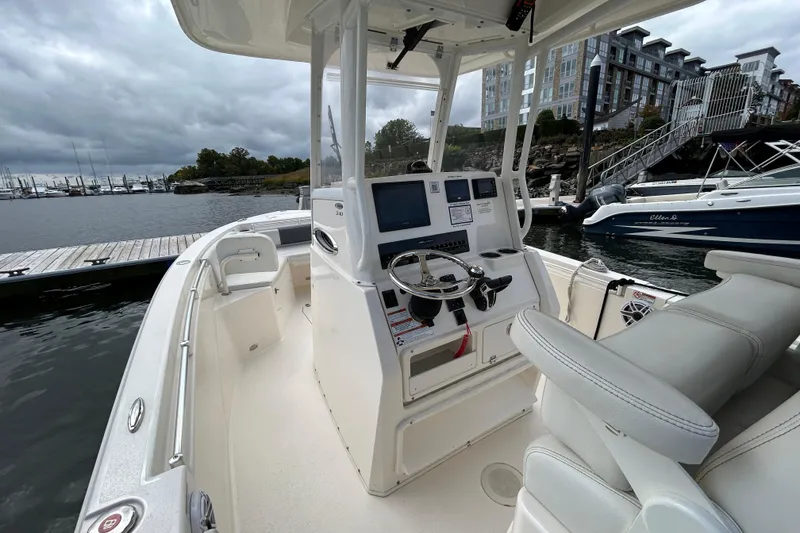 Slide: The Image of 2023 Cobia 240 Center Console boat docked at marina with overcast sky. - 24