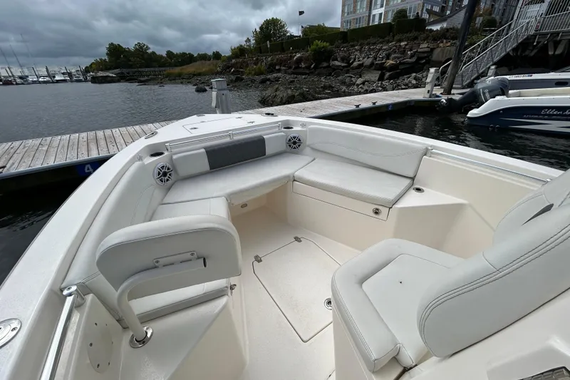 Slide: The Image of 2023 Cobia 240 Center Console boat interior at dock, featuring spacious seating. - 25