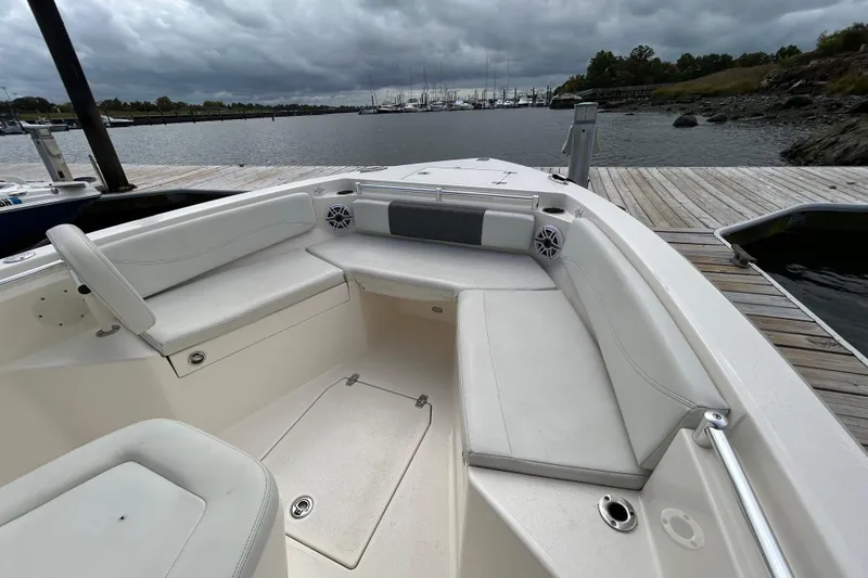 Slide: The Image of 2023 Cobia 240 Center Console boat docked, featuring spacious seating and overcast sky. - 27