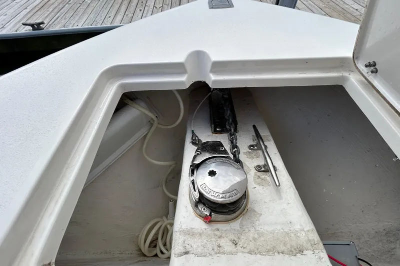 Slide: The Image of 2023 Cobia 240 Center Console anchor locker with winch and chain detail. - 28